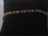 black velvet cushion with a gold chain bracelet on it