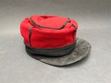 un chapeau rouge orné d'un ruban noir sur le dessus