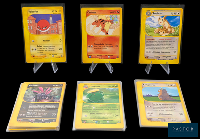 Plusieurs cartes Pokémon sont exposées sur un fond noir.