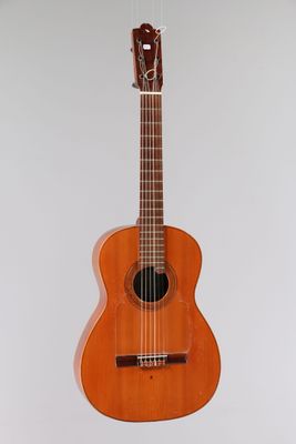 un gros plan d'une guitare acoustique accrochée au mur