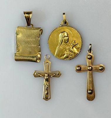 three gold crosses and a gold medal on a white surface
