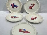 four plates with shoes on them hanging on a wall