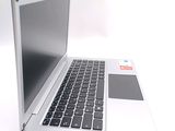 a silver laptop with a black keyboard on a white surface