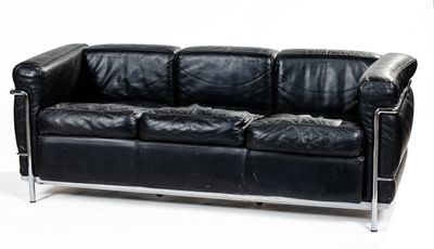 a black leather couch sitting on a white surface
