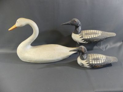 three carved ducks sitting on top of a table next to each other