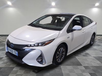 La Toyota Prius blanche est garée dans une pièce dont le sol est à carreaux.