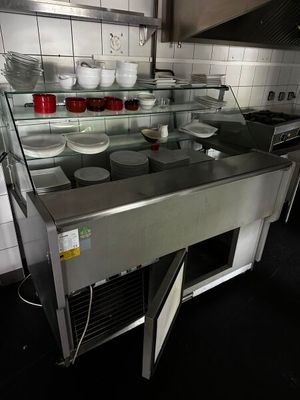 plan de travail en acier inoxydable dans une cuisine professionnelle, sur lequel sont posés des plats