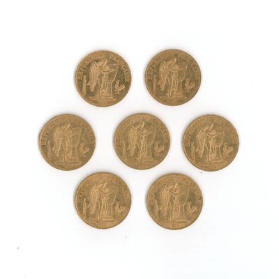 six types différents de pièces d'or sur une surface blanche