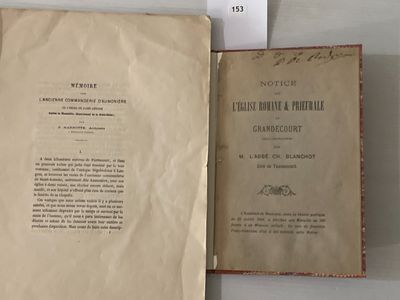 un livre ouvert posé sur une table, à côté d'un panneau