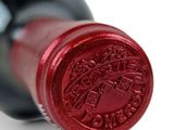 a close up of a wine bottle with a red seal on it