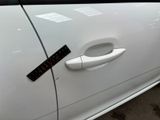 a sticker on the door handle of a white car