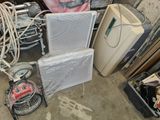 un tas de vieux appareils électroménagers et d'autres objets dans un garage