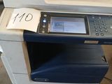 une imprimante multifonction posée au sommet d'un tas de bric-à-brac