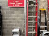 de nombreuses échelles et un panneau sur le côté d'un immeuble