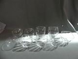 several empty wine glasses lined up on a table in front of a curtain