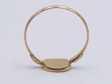 a close up of a gold ring with a small disc on it