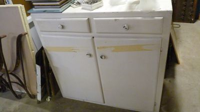 une armoire blanche avec un évier au milieu d'une pièce