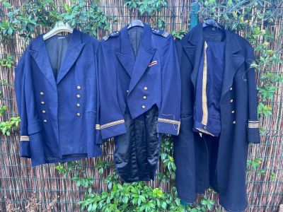 trois vestes et pantalons pour homme suspendus à une clôture en bambou