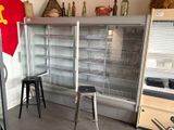 une photo d'une cuisine avec un réfrigérateur et des tabourets de bar