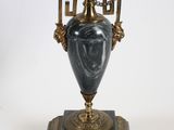 a vase with chains hanging from it on a stand