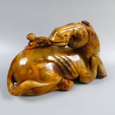 a statue of a dog laying on its back on a table