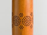 a close up of a wooden object with holes on it