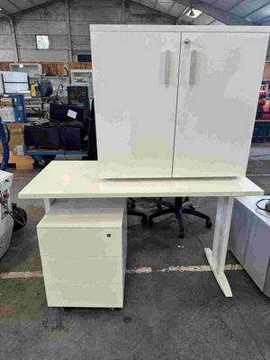 a desk with a cabinet and a chair in a warehouse