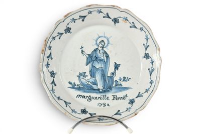 une assiette bleue et blanche sur laquelle est représenté un saint