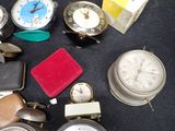 many different types of clocks on a black table