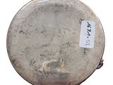 an old silver plate with a tag on it sitting on a white surface
