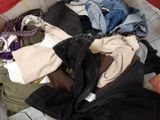 a suitcase full of clothes and clothes on a bed