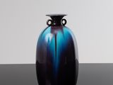 un vase bleu et noir posé sur une table noire