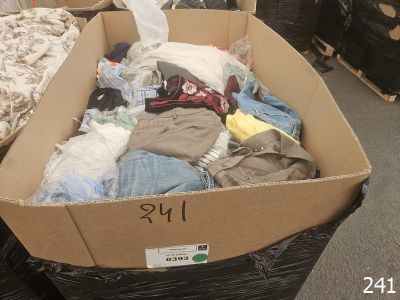 a cardboard box full of clothes on the floor
