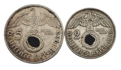 deux pièces d'argent ornées de têtes d'aigle, dont l'une présente un trou au milieu