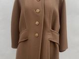 brown wool coat on a mannequin stand on a black and white checkered floor
