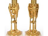 paire de vases plaqués or sur socles en marbre, munis d'anses et de poignées
