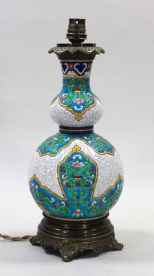 un vase bleu et blanc posé sur une table sur laquelle se trouve une lampe