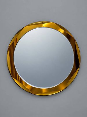 un miroir rond avec un cadre doré accroché au mur