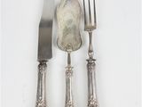 trois fourchettes et un couteau sur une table blanche