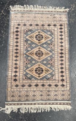 an old rug with fringes on a black floor