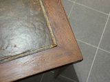 une table sur laquelle est posé un livre, posée sur un sol carrelé