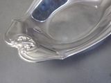 a silver plate with a spoon in it on a table