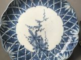 a blue and white plate sitting on a table next to a pair of scissors