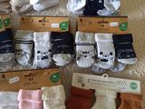 many pairs of socks and mittens on the bed
