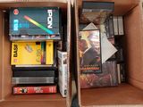 deux cartons remplis de DVD et de jeux posés par terre