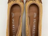 a pair of tan shoes with a woven sole and a gold buckle
