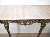 a marble top table with a gold frame on it