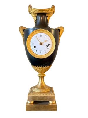 un vase noir et doré orné d'une horloge