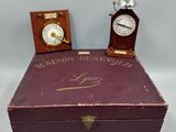 an old wooden box with a clock on top of it next to a small wooden box with a clock on top