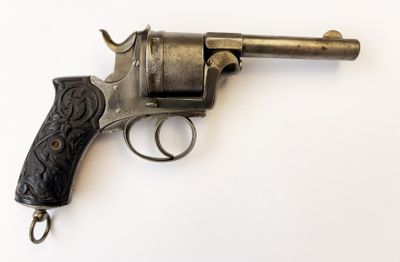 un vieux pistolet avec une poignée en bois sur une surface blanche